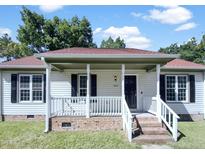 Charming home with a cozy covered front porch, brick stairs, and black shutters at 1405 Cross Link Rd, Raleigh, NC 27610