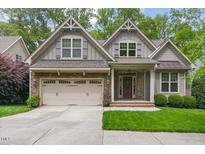 Charming home featuring a stone facade, gray siding, a well-manicured lawn, and an attached two-car garage at 144 Cobble Ridge Dr, Pittsboro, NC 27312
