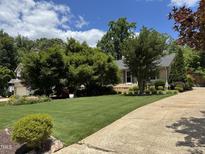 Beautiful front yard showcasing lush green lawn, trees, and well-maintained landscaping under a sunny sky at 2009 Mallard Ln, Raleigh, NC 27609