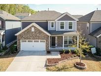 Charming two-story home with stone accents, a two-car garage, and a beautifully landscaped front yard at 2221 Holtwood Way, Apex, NC 27523