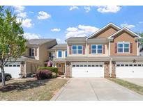 Charming two-story townhome with an attached two car garage and an inviting facade with red shutters at 225 Mayfield Dr, Apex, NC 27539