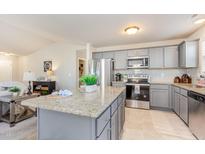 Bright kitchen boasts granite counters, stainless appliances, tile backsplash and center island at 25 Cornfield Ln, Benson, NC 27504