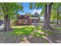 Charming two-story home with mature trees, a covered porch, and beautiful landscaping at 2904 Falkirk Pl, Raleigh, NC 27604