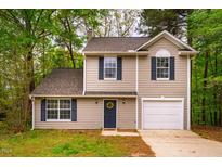 Charming two-story home featuring neutral siding, blue shutters, and a welcoming front door with a decorative wreath at 3 Little Stone Cir, Durham, NC 27703