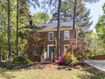 Charming brick home with blue shutters and a well-manicured lawn and garden at 301 Trappers Sack Rd, Cary, NC 27513