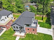 Stunning aerial view of a modern home with a rooftop deck and a well-manicured lawn at 337 Merrywood Dr, Raleigh, NC 27610