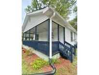 Charming home featuring a cozy front porch with blue accents and a well-maintained exterior at 409 Neathery St, Henderson, NC 27536