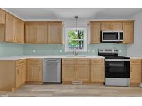 Bright kitchen features stainless steel appliances, sleek countertops, and ample wood cabinetry at 419 Joy Dr, Garner, NC 27529