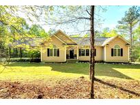Charming single story home featuring a landscaped lawn, symmetrical windows, and a comfortable covered carport at 452 Dogwood Trl, Henderson, NC 27537