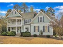 Charming two-story home featuring a double front porch and manicured landscaping at 5109 Dove Forest Ln, Apex, NC 27539