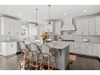 Bright kitchen features a large island with seating, stainless steel appliances, and white cabinetry at 512 Montague Ln, Raleigh, NC 27601