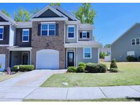 Charming two-story townhome with a brick and siding facade, attached garage, and manicured lawn at 547 Historic Dr, Hillsborough, NC 27278