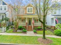Charming two-story home with a brick porch, landscaped yard, and an American flag waving proudly at 607 Millbrook Dr, Pittsboro, NC 27312