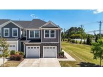 Beautiful townhome with a two-car garage and well-manicured landscaping, offering a welcoming curb appeal at 608 Creekway Dr, Fuquay Varina, NC 27526