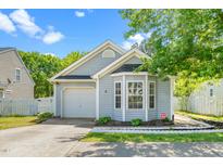 Charming single-story home with light blue siding, well-maintained landscaping, and attached garage at 611 Edenberry Dr, Durham, NC 27713