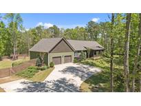 Beautiful exterior featuring lush landscaping, two-car garage, and a large driveway at 626 Bailey Rd, Coats, NC 27521