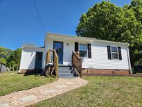 Charming home with a bright blue front door, white siding, and a stone pathway leading up to the entrance at 710 Dothan Ave, Burlington, NC 27217