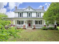 Charming two-story farmhouse with a welcoming porch and beautifully landscaped front yard at 7129 Dexter Rd, Oxford, NC 27565