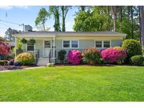 Charming single-story home featuring a well-manicured lawn and mature azaleas, creating a picturesque curb appeal at 806 Edmund St, Raleigh, NC 27604