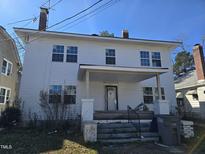 Charming two-story home featuring a covered front porch and ample windows under a clear blue sky at 827 Sunset Ave, Rocky Mount, NC 27804
