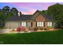 Charming single-story home boasts a manicured lawn, brick accents, and a welcoming front porch at 910 S Third St, Mebane, NC 27302