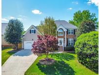 Charming two-story home featuring a well-manicured lawn and inviting curb appeal in a suburban neighborhood at 102 Traviliah Oaks Ln, Cary, NC 27518
