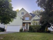 Charming two-story home with a well-maintained lawn and mature trees providing ample shade at 105 Dairy Ct, Chapel Hill, NC 27516