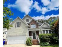 Charming two-story home featuring a symmetrical design, light siding, brick accents, and an attached two-car garage at 105 Dairy Ct, Chapel Hill, NC 27516