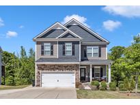 Charming two-story home with a mix of stone and siding, a two car garage, and a covered front porch at 106 Neuse Bluff Cir, Clayton, NC 27527