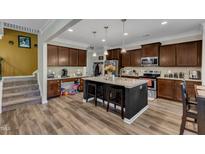 Well-equipped kitchen with dark wood cabinets, granite countertops, and an island with seating at 106 Neuse Bluff Cir, Clayton, NC 27527