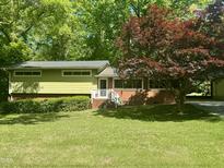 Charming home with brick facade, lush lawn, and mature landscaping creates inviting curb appeal at 1102 Poplar Ave, Garner, NC 27529