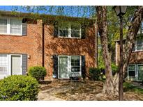 Charming brick townhome with black shutters, well-maintained landscaping, and inviting entrance at 115 Coleridge Ct, Carrboro, NC 27510