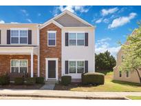 Charming townhome with brick and vinyl siding, complemented by dark shutters and a well-maintained lawn at 1304 Cozart St # 216, Durham, NC 27704