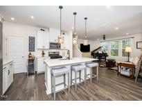 Modern kitchen with white cabinets, a center island with seating, and stainless steel appliances at 1403 Chipping Dr, Apex, NC 27502