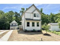 Charming two-story home features a white exterior, gray trim, and a cozy front porch at 1448A Maplewood Dr, Durham, NC 27704
