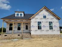New construction home featuring brick facade and protective house wrap in a residential neighborhood at 152 Cultivator Ct, Angier, NC 27501