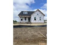 New construction home featuring a brick foundation and protective wrap awaiting finishing touches at 152 Cultivator Ct, Angier, NC 27501