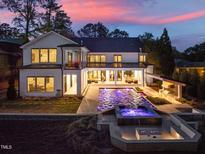 Stunning backyard with a large pool, hot tub, outdoor kitchen, and fire pit, perfect for entertaining and relaxation at 1616 Hunting Ridge Rd, Raleigh, NC 27615