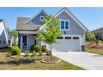 Charming gray home featuring an attached garage, manicured landscaping, and inviting front entrance at 226 Mahogany Run, Raleigh, NC 27610