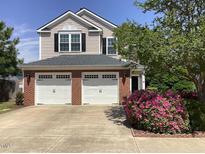 Charming two-story home with a brick facade, two-car garage, and landscaped front yard at 2428 Diquedo Dr, Raleigh, NC 27604