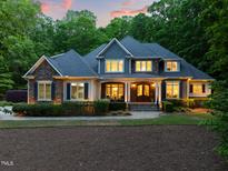 Charming two-story home with stone and siding exterior, manicured landscaping, and inviting front porch at 3513 Forest Oaks Dr, Chapel Hill, NC 27514