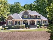 Charming two-story home with stone and siding, complemented by a landscaped yard and a welcoming front porch at 3513 Forest Oaks Dr, Chapel Hill, NC 27514
