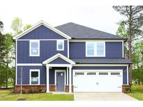 Charming two-story home with a well-manicured lawn and a two-car garage at 3813 Rosebush Dr, Zebulon, NC 27597