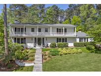 Beautiful two-story home with a white brick facade, well-manicured lawn, and a charming balcony at 3826 Regent Rd, Durham, NC 27707