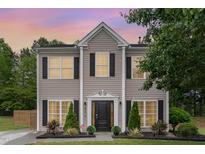 Charming two-story home featuring symmetrical windows, black shutters, manicured landscaping, and inviting front door at 406 Sapphire Dr, Durham, NC 27703