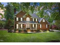 Charming red brick two-story home with a welcoming front porch and well-maintained landscaping at 4513 Touchstone Forest Rd, Raleigh, NC 27612