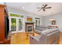 Bright living room featuring a fireplace, ceiling fan, hardwood floors, and access to a screened in porch at 511 Hillsborough St # 103, Chapel Hill, NC 27514