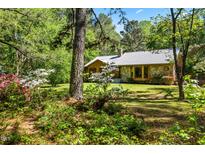 Charming stone and wood home nestled in a lush, wooded lot with flowering bushes at 5204 William And Mary, Raleigh, NC 27616