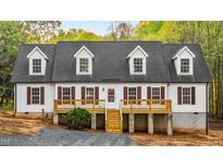 Charming home featuring a covered porch, white siding, a dark gray roof and meticulous landscaping at 580 Greenbriar Farm Trl, Siler City, NC 27344