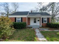 Charming single-story brick home with landscaped front yard and inviting entryway at 704 N King Charles Rd, Raleigh, NC 27610